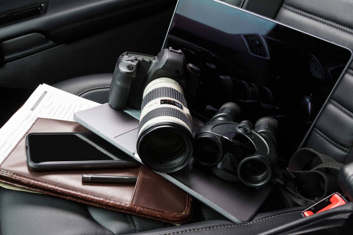 camera and binoculars sitting on the from seat of a vehicle